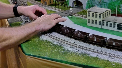 BEMIDJI, MN - 14 MAY 2016: Man adds an additional Toy Model Train Car. Stock Footage 106103579