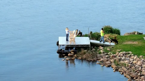 BEMIDJI, MN - 2 JUN 2023: Couple and dog enjoy time at the lake. Stock Footage 251756878