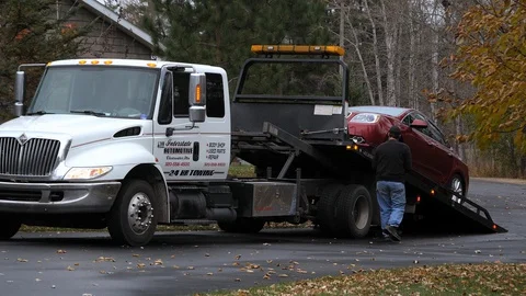 BEMIDJI, MN - 27 OCT 2019: Red car is loaded onto a flatbed truck to transport Video stock 128558078