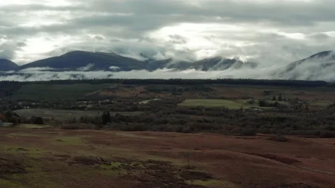 Ben Nevis mountain range surrounded by clouds at sunrise - aerial footage 4k Stock Footage 167784443