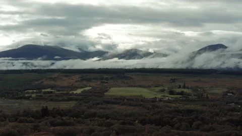 Ben Nevis mountain range surrounded by clouds at sunrise - aerial footage 4k Stock Footage 167784469