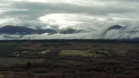 Ben Nevis mountain range surrounded by clouds at sunrise - aerial footage 4k Stock Footage 167784486