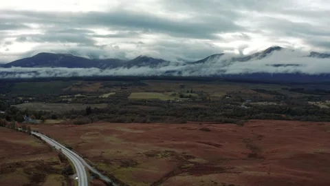 Ben Nevis mountain range surrounded by clouds at sunrise - aerial footage 4k Stock Footage 167784515