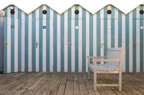 Bench with beach cabins background Stock Photos