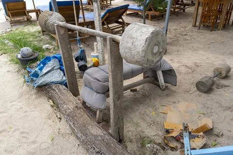 Bench on a beach with a large weight made of concrete on top of it Stock Photos
