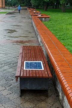 A bench with a built-in solar panel for charging phones. 스톡 사진