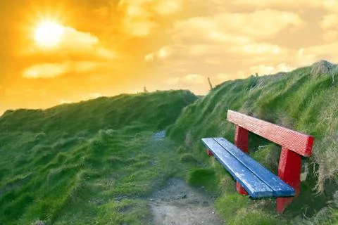 Bench on a cliff edge at sunset Stock Photos