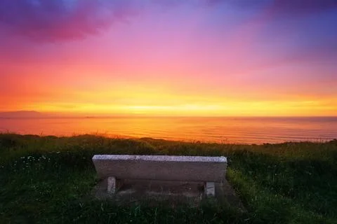 Bench on cliff at sunset Stock Photos