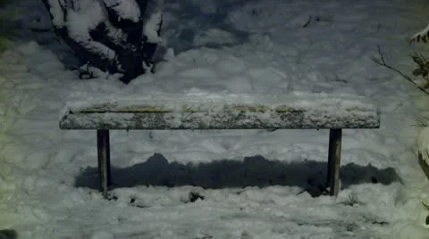 Bench covered with snow during the night 4 Stock Footage 10734757