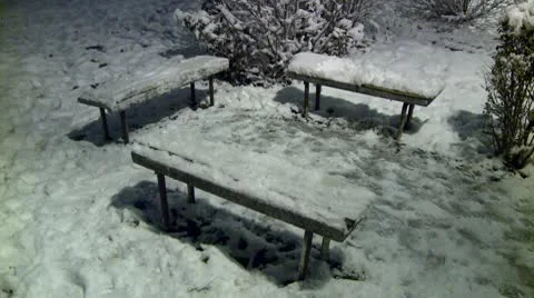 Bench covered with snow during the night 3 Stock Footage 10734800