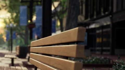 Bench on empty sidewalk in city during sunset with buildings nearby Stock Footage 340016315