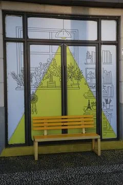 A bench in front of the window, painted with a triangle and lines on it, fe.. Stock Photos