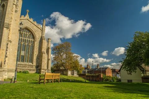 Bench on grass in front of a Gothic cathedral at Saffron Walden, England 스톡 사진