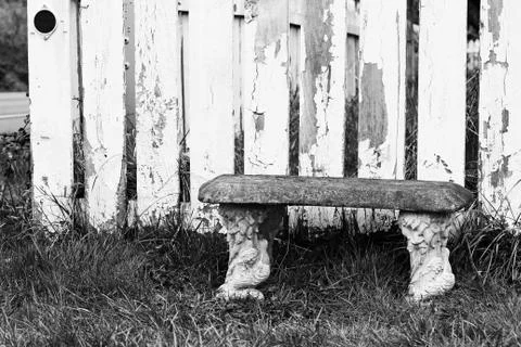 Bench in Grass in Front of Old Wood Fence (Black and White) Stock Photos