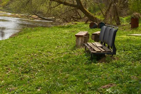 A bench made from an old broken car seat on the riverbank Stock Photos
