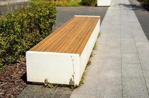 Bench made of a solid concrete block with wooden boards on top Stock Photos