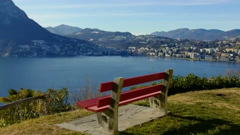 Bench with Mountain View over Lake Lugano in a Sunny Day and Cityscape Stock Footage 191953853