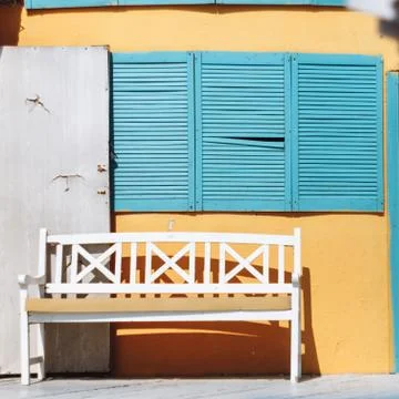 A bench, open door and blue blinds. Stock Photos