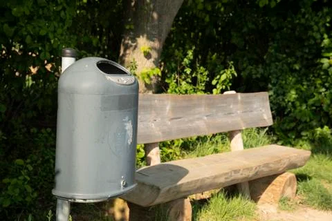 Bench in the open with a garbage can for resting Stock Photos