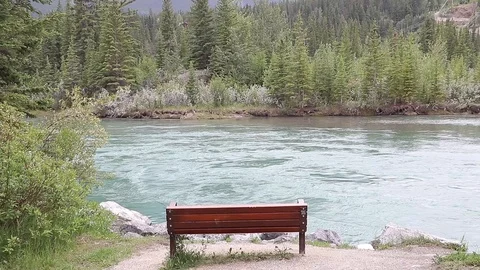 Bench overlooking flowing river Stock Footage 112365798