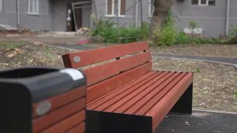 Bench paired with matching trash bin stands in quiet square Vídeo Stock 327796276