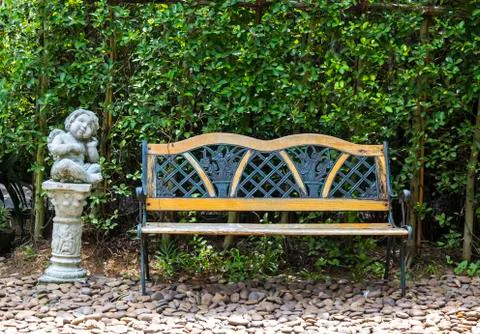 Bench in park and a statue Stock Photos