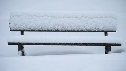 Bench in a park covered completely by snow after heavy snowfall 스톡 동영상 71325002