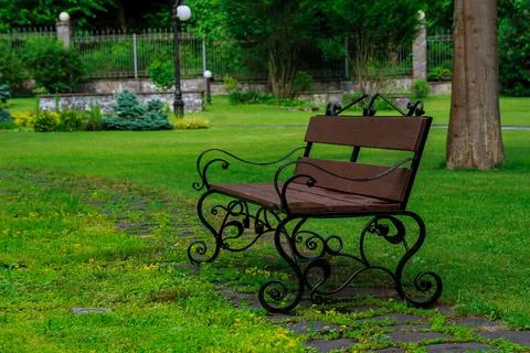Bench in the park on the green grass Stock Photos