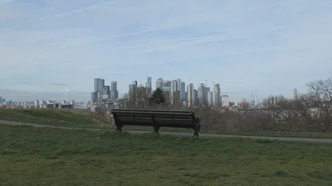 A bench in a park with the view of a financial district in the background. Stock Footage 276711954