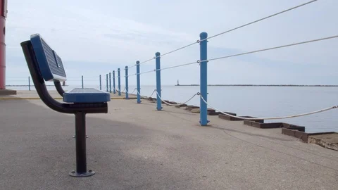 Bench on the pier overlooking the lake by the lighthouse, 4k60p Stock Footage 128852236