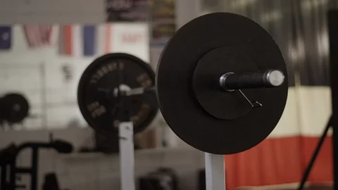 Bench press with flags waving in the background in Muay Thai boxing gym 스톡 동영상 104549656