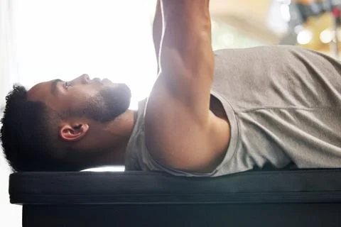 Bench press over sofas any day. a young man working out with a bench press in a Stock Photos