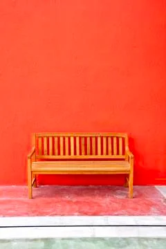 Bench on red wall background. Stock Photos