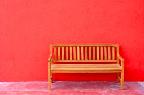 Bench on red wall background. Stock Photos
