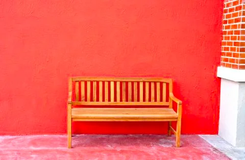 Bench on red wall. Stock Photos