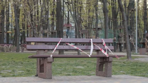Bench with red white tape in front of empty rope park Stock-Footage 129240465