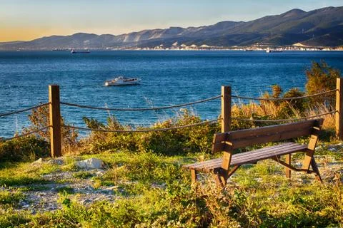 Bench by the sea. Waiting for the sunset on the cliff. A place of solitude. Stock Photos
