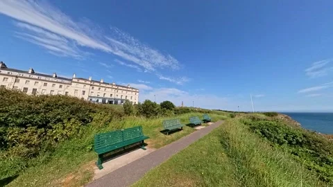Bench seating on the clifftop overlooking Whitby harbour Vídeo Stock 245430323