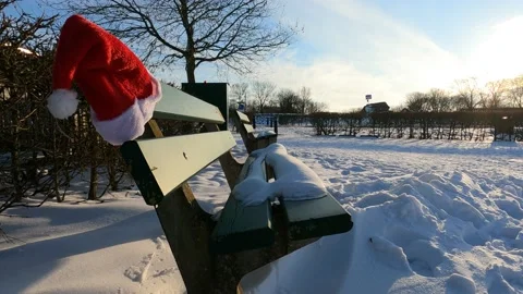 Bench with snow on it and a Santa hat. Christmas feeling in the winter. Stock Footage 148239495
