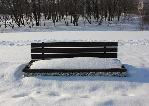 A bench with snow in winter Stock Photos