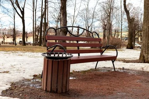A bench in a spring park, where it is dirty and there is no greenery yet Stock Photos