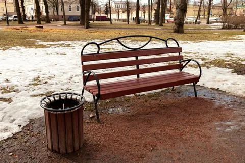 A bench in a spring park, where it is dirty and there is no greenery yet Stock Photos