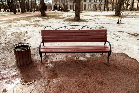 A bench in a spring park, where it is dirty and there is no greenery yet Stock Photos