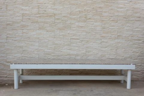 Bench with stone walls for a background image. Stock Photos