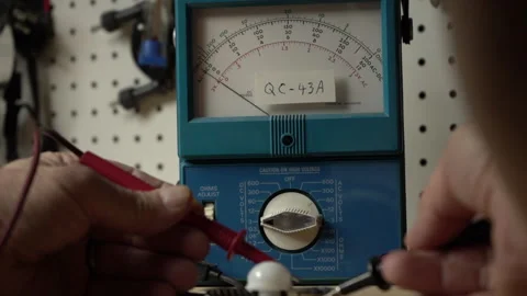 Bench testing an electronic device using an analog voltmeter Stock Footage 198879885
