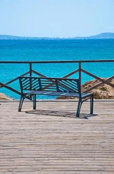 Bench by turquoise ocean Stock Photos