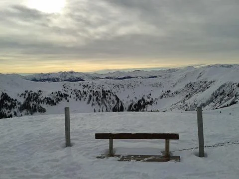 A bench in wintertime at sunset Stock Photos