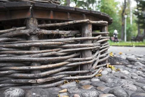 Bench is woven from branches . Decorative elements of bench in public park Fotos Stock
