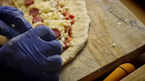 Bend the corners of the dough. We prepare pide witch salami. 4k video Stock Footage 157297865