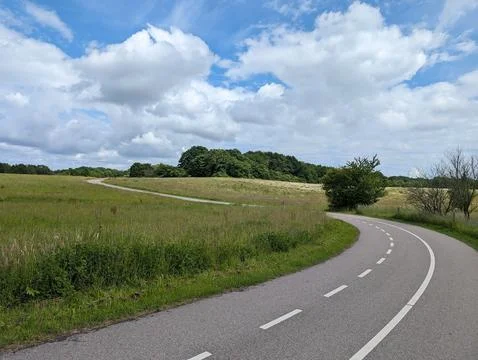 A Bend in the Road with Clouds Above Stock Photos